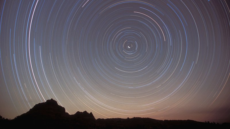 A time-lapse photo of the night sky over Coyote Buttes, Ariz., shows stars leaving circular trails around a bright point in the middle, which is the North Star.